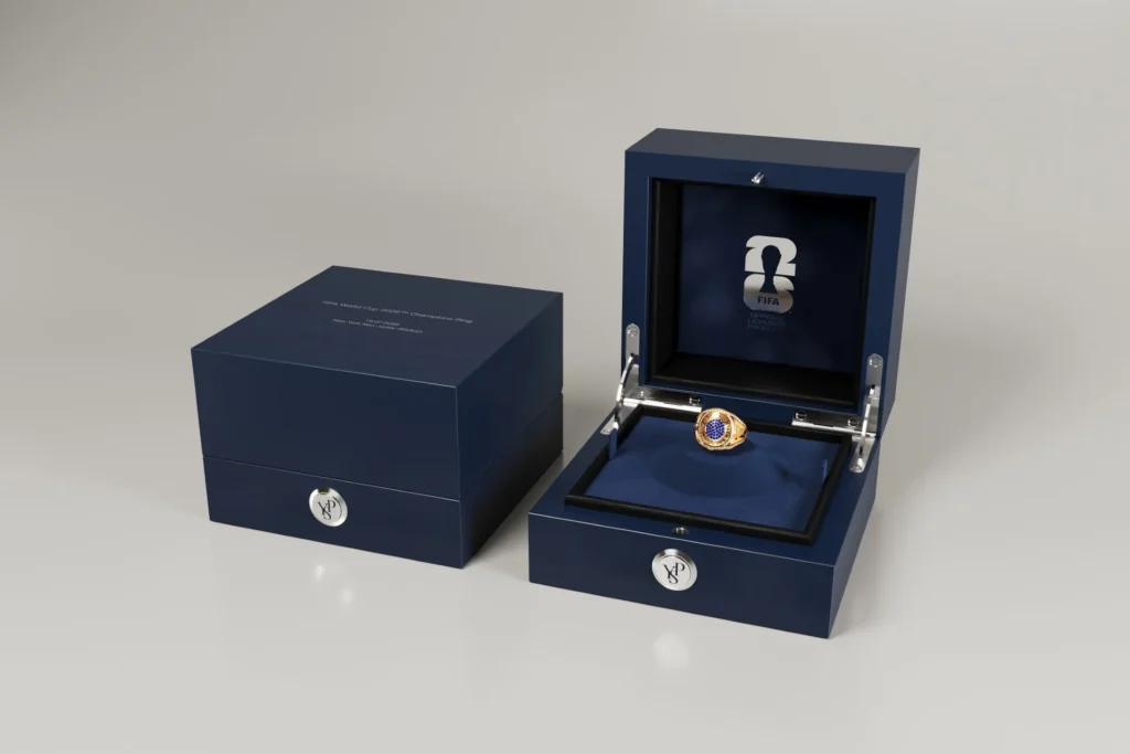 Another 1,996 FIFA World Cup 2026™ Championship Rings to Be Released to the Public Luxury presentation box displaying the official FIFA World Cup 2026 Champions Ring in gold with blue gemstones, crafted for players and collectors.